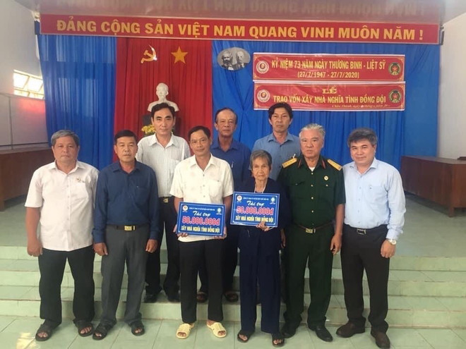 Cựu chiến binh Trần Quốc Việt trao kinh phí xây nhà nghĩa tình đồng đội cho các gia đình. (Ảnh: Huỳnh Phúc Hậu/TTXVN) 77 năm thành lập Quân đội: Những ngôi nhà nghĩa tình đồng đội ảnh 2