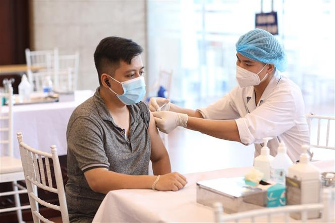 Nhân viên y tế tiêm vaccine phòng COVID-19 cho người dân quận Hoàn Kiếm, chiều 15/9. (Ảnh: Minh Quyết/TTXVN) Hà Nội: Tiêm ít nhất 1 mũi vaccine cho người bốc dỡ hàng hóa ảnh 1