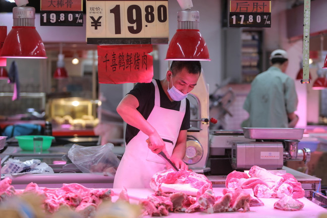 Người dân bán thực phẩm tại một khu chợ ở Trung Quốc. (Ảnh: AFP/TTXVN) Trung Quốc: Đặt lại mục tiêu tăng trưởng và lộ trình hậu dịch COVID-19 ảnh 2
