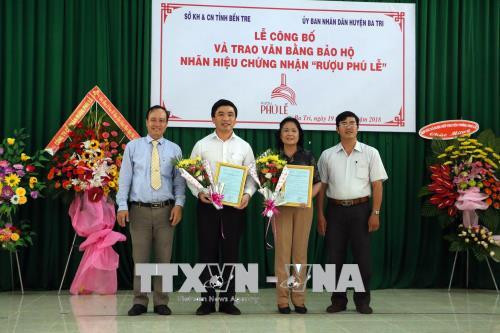 Lãnh đạo UBND huyện Ba Tri trao giấy chứng nhận quyền sử dụng nhãn hiệu "Rượu Phú Lễ" cho các tập thể sản xuất rượu. Ảnh: Trần Thị Thu Hiền - TTXVN Sự kiện trong nước 18-24/6: Vĩnh biệt giáo sư Phan Huy Lê ảnh 3