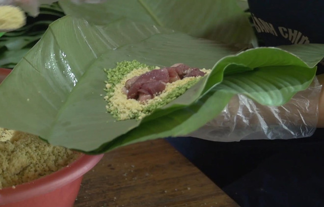 Một công đoạn gói bánh chưng gù. (Nguồn: Vietnam+) Bánh chưng gù - Đặc sản trứ danh vùng cao nguyên đá Hà Giang ảnh 2