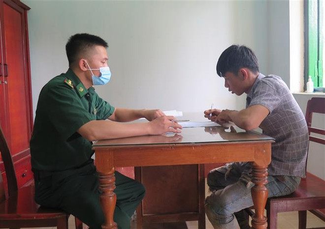 Lực lượng chức năng tiến hành lấy lời khai các đối tượng. (Ảnh: Dư Toán/TTXVN) Kon Tum: Phát hiện, bắt giữ 10 người có hành vi xuất cảnh trái phép ảnh 1