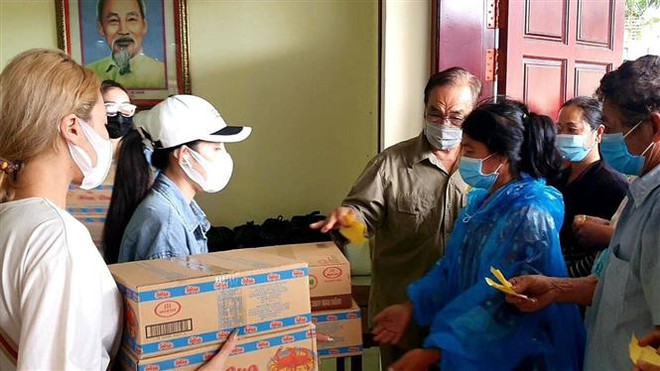 Mỗi phần quà gồm 2 thùng mỳ gói hoặc 1 thùng mì gói và 10 kg gạo. (Ảnh: Trần Long/TTXVN) Những tấm lòng chia sẻ đến với người gốc Việt tại Preah Sihanouk ảnh 1