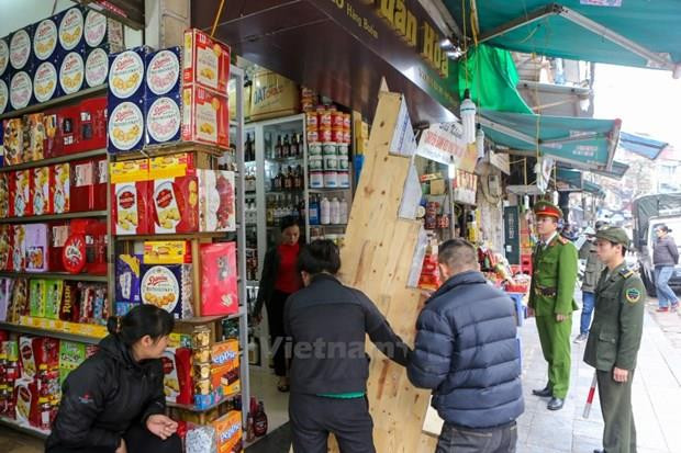 Lực lượng công an, dân phòng các phường ở Hà Nội đồng loạt kiểm tra, xử phạt các hành vi lấn chiếm vỉa hè trái phép. (Ảnh: Minh Sơn/Vietnam+) Hà Nội đẩy mạnh bảo vệ hành lang an toàn giao thông đường bộ ảnh 2
