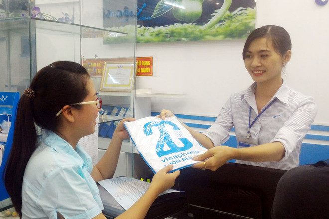 Tặng quà cho khách hàng nhân dịp kỷ niệm 20 năm VinaPhone (26/6/1996-26/6/2016) tại điểm giao dịch ở Đồng Hới, Quảng Bình. (Ảnh: T.H/Vietnam+) Vinaphone đặt mục tiêu vị trí thứ hai trên thị trường viễn thông ảnh 2