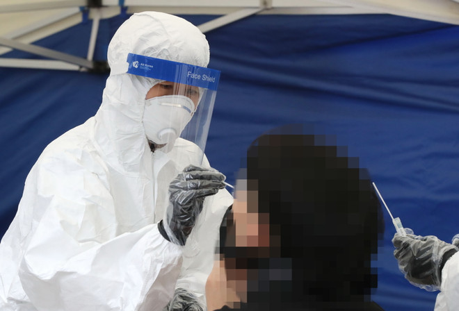 Nhân viên y tế lấy mẫu xét nghiệm COVID-19 ở Seoul, Hàn Quốc. (Ảnh: Yonhap/TTXVN) Tình hình dịch bệnh COVID-19 tại Australia, Hàn Quốc và Trung Quốc ảnh 1