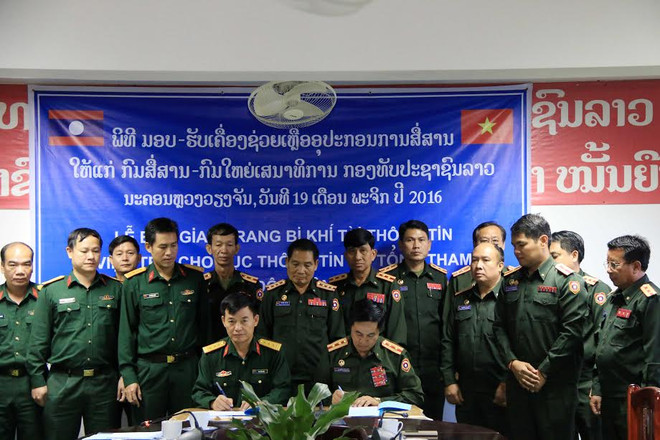 Đại diện Bộ Tư lệnh Thông tin liên lạc, Bộ Quốc phòng Việt Nam (trái) và Đại tá Sayaphon Chanthavong (phải), Cục trưởng Cục trưởng Cục Thông tin, Bộ Tổng tham mưu Quân đội Nhân dân Lào, đang ký Biên bản bàn giao trang thiết bị tại buổi lễ. (Ảnh: Phạm Kiên/Vietnam+) Việt Nam hỗ trợ trang thiết bị, khí tài thông tin cho Quân đội Lào ảnh 2