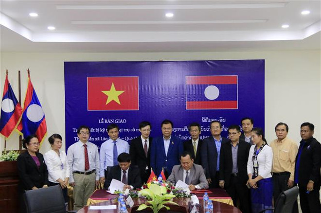 Lãnh đạo TTXVN và KPL ký Biên bản bàn giao trang thiết bị, kỹ thuật. (Ảnh: Phạm Kiên/TTXVN) TTXVN-KPL: Cầu nối giúp vun đắp và gìn giữ quan hệ đặc biệt Việt-Lào ảnh 1