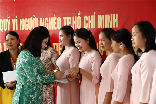 Bà Vũ Tú Oanh, Tham tán thường trực cộng đồng Đại sứ quán Việt Nam tại Lào trao tiền hỗ trợ cho giáo viên Trường Song ngữ Lào - Việt Nam Nguyễn Du. (Ảnh: Phạm Kiên/TTXVN) Trao tiền hỗ trợ giáo viên Trường Song ngữ Lào-Việt Nam Nguyễn Du ảnh 1