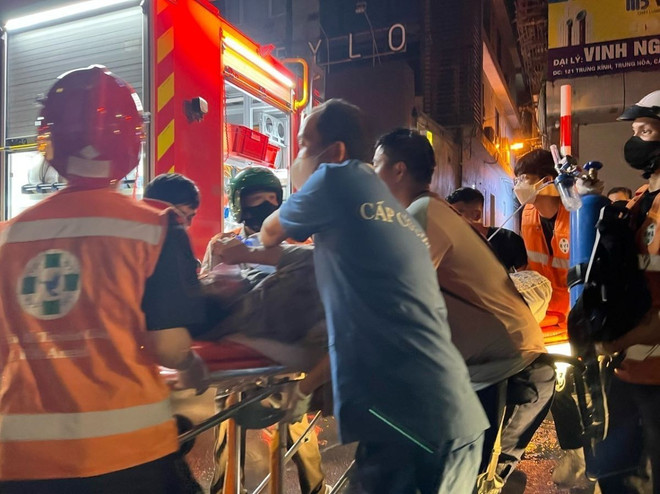 Lực lượng chức năng đưa nạn nhân đi cấp cứu. (Ảnh: TTXVN phát) ttxvn_chay_lon_tai_nha_tro_khu_vuc_trung_kinh_khien_14_nguoi_chet_2405-2.jpg