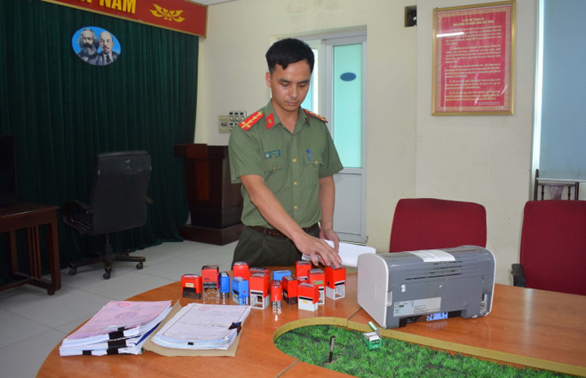 Lực lượng Công an thu giữ vật chứng vụ án. (Ảnh: Đinh Văn Nhiều/TTXVN) Khởi tố 4 đối tượng mua bán hóa đơn trị giá hàng nghìn tỷ đồng ảnh 2