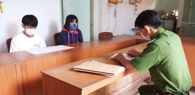 Đối tượng Trần Quang Trí và người giám hộ tại cơ quan điều tra. (Ảnh: TTXVN phát) Khởi tố đối tượng cố ý lao xe vào lực lượng phòng, chống dịch COVID-19 ảnh 1
