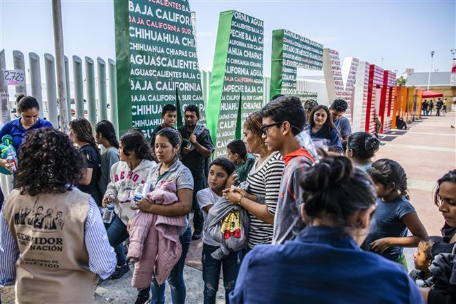Người di cư bị trục xuất khỏi Mỹ tập trung tại khu vực biên giới Mỹ-Mexico, trước khi được đưa về một trại tạm ở Tijuana, Mexico ngày 22/7/2019. (Ảnh: AFP/TTXVN) Thẩm phán Mỹ chặn quy định mới về người di cư của chính quyền ảnh 1