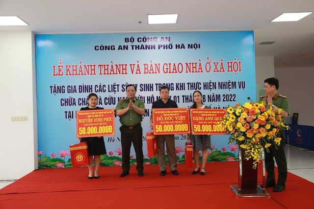Trung tướng Nguyễn Hải Trung, Bí thư Đảng ủy, Giám đốc Công an thành phố Hà Nội tặng quà cho nhân thân các liệt sỹ phòng cháy chữa cháy quận Cầu Giấy. (Nguồn: Bộ Công an) Hà Nội: Bàn giao nhà ở xã hội tặng gia đình liệt sỹ phòng, chữa cháy ảnh 1
