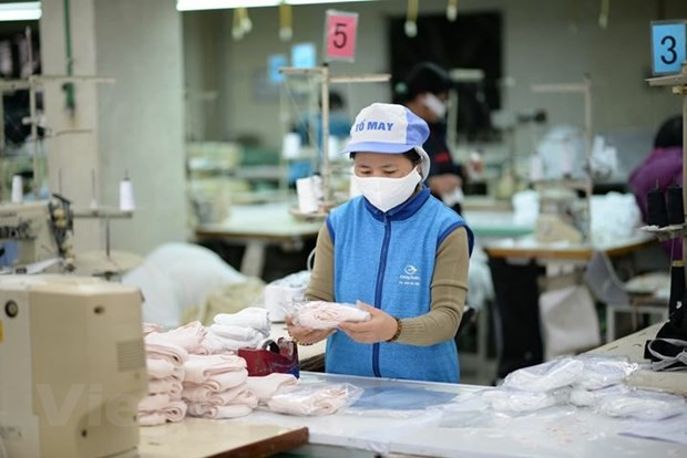 Doanh nghiệp dệt may sản xuất khẩu trang phục vụ thị trường. (Ảnh: Đức Duy/Vietnam+) Siêu thị cung ứng đủ khẩu trang, nước rửa tay phục vụ người tiêu dùng ảnh 1