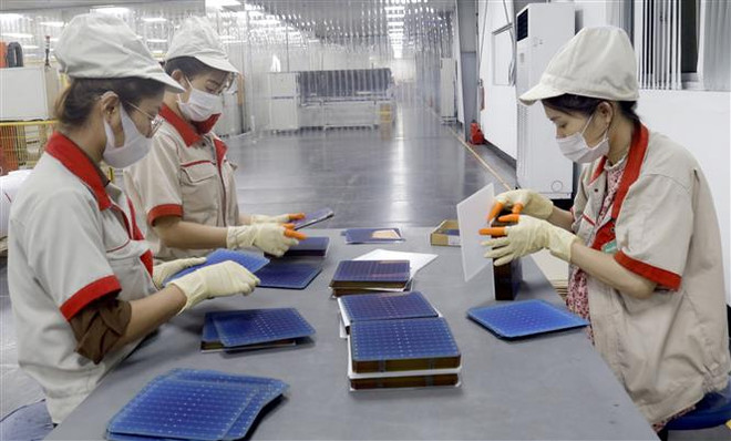 Công nhân Công ty cổ phần Vietnam Sunegry tại Khu công nghiệp Đình Trám, Bắc Giang trong dây chuyền sản xuất tấm pin năng lượng Mặt Trời. (Ảnh: Đồng Thúy/TTXVN) Mỹ gia hạn điều tra lẩn tránh thuế phòng vệ thương mại hàng Việt Nam ảnh 1