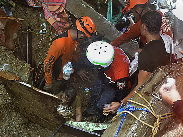 Nhân viên cứu hộ tìm kiếm nạn nhân trong trận lở đất do mưa lớn sau bão Jiangmi tại Catbalogan, tỉnh Samar, miền Tây Philippines ngày 31/12/2014. (Ảnh: AFP/TTXVN) Australia tặng Philippines tàu đổ bộ quân sự nhằm cứu trợ thiên tai ảnh 1