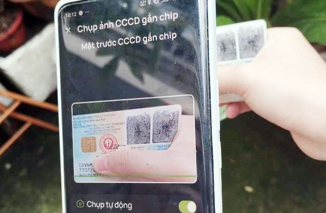 Nhiều khách hàng gặp khó khăn trong khâu quét thông tin trên căn cước công dân. (Ảnh: Vietnam+) a copy.JPG