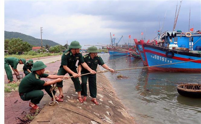 Lực lượng Đồn biên phòng Cửa Sót giúp ngư dân giằng néo tàu thuyền. (Ảnh: Công Tường/TTXVN) Các địa phương tích cực ứng phó với bão số 4 đang tiến gần bờ ảnh 1
