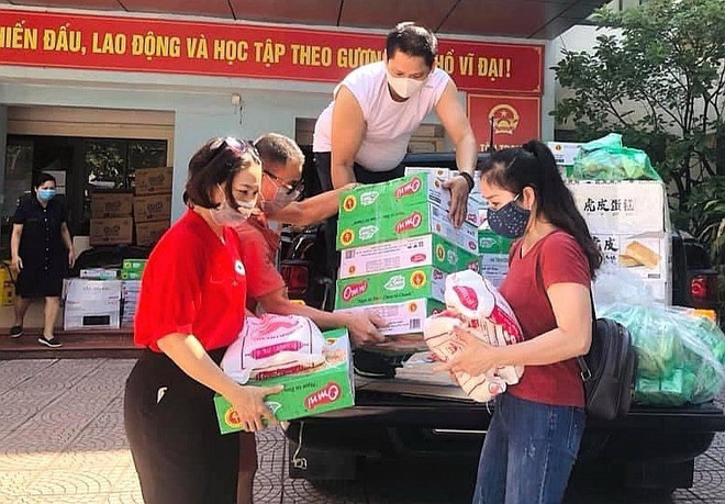 Hội Chữ thập đỏ quận Ba Đình tặng các phần quà hộ trợ tới lực lượng tuyến đầu tại các chốt phòng dịch và người dân bị ảnh ảnh hưởng trên địa bàn quận. (Ảnh: TTXVN phát) Phụ nữ, giáo viên Thủ đô đồng hành cùng phòng, chống dịch COVID-19 ảnh 1