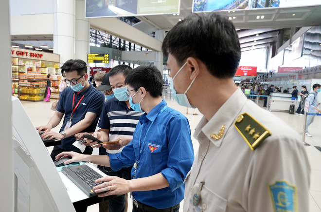 Cảng hàng không Nội Bài bố trí đội thanh niên xung kích hỗ trợ khách khai báo y tế tại 6 cây máy tính kết nối internet… để giúp hành khách hoàn thành nhanh nhất thủ tục khai báo y tế. (Ảnh: CTV/Vietnam+) Hãng bay phải chịu trách nhiệm kiểm soát hành khách khai báo y tế ảnh 1
