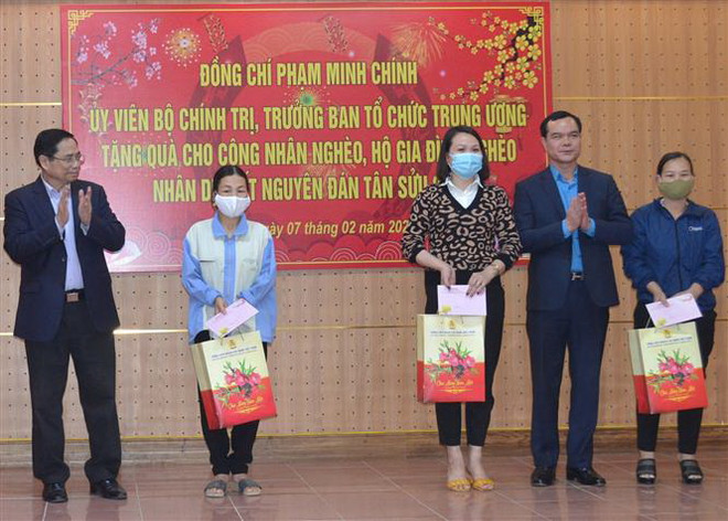 Trưởng Ban Tổ chức Trung ương Phạm Minh Chính cùng Chủ tịch Tổng Liên đoàn Lao động Việt Nam trao quà Tết cho công nhân lao động hoàn cảnh khó khăn tỉnh Hòa Bình. (Ảnh: Thanh Hải/TTXVN) Trưởng Ban Tổ chức Trung ương thăm, tặng quà Tết tại tỉnh Hòa Bình ảnh 1