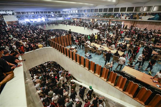 Người biểu tình ủng hộ giáo sỹ Hồi giáo dòng Shiite Moqtada al-Sadr xông vào tòa nhà Quốc hội Iraq ở thủ đô Baghdad ngày 30/7/2022. (Ảnh: AFP/TTXVN) Liên hợp quốc và AL kêu gọi chấm dứt leo thang căng thẳng ở Iraq ảnh 1