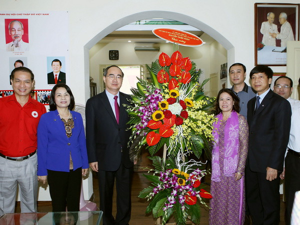 Ủy viên Bộ Chính trị, Chủ tịch Ủy ban Trung ương MTTQ Việt Nam Nguyễn Thiện Nhân đến tặng hoa chúc mừng 70 năm, Hội Chữ thập Đỏ Việt Nam. (Ảnh: Nguyễn Dân/TTXVN) Hội Chữ thập Đỏ: 70 năm tỏa sáng những hành trình cứu trợ nhân đạo ảnh 1