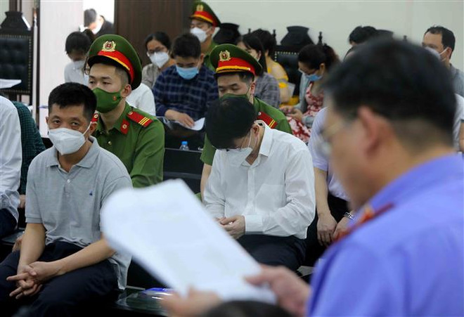 Các bị cáo nghe đại diện Viện kiểm sát công bố cáo trạng tại phiên tòa. (Ảnh: An Đăng/TTXVN) Xét xử vụ thuốc giả: Bị cáo Trương Quốc Cường xin giảm án cho cấp dưới ảnh 2