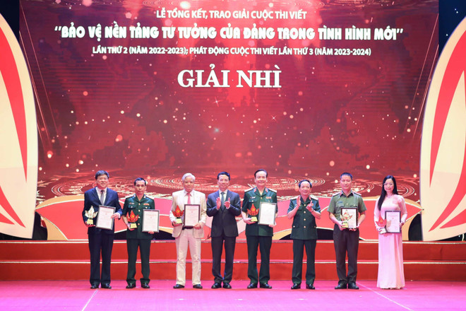 Trung tướng Trịnh Văn Quyết, Phó chủ nhiệm Tổng cục Chính trị Quân đội nhân dân Việt Nam cùng Bộ trưởng Bộ Thông tin và Truyền thông Nguyễn Mạnh Hùng trao giải Nhì cho tác giả. (Ảnh: Thanh Tùng/TTXVN) Tổng kết, trao giải cuộc thi viết Bảo vệ nền tảng tư tưởng của Đảng ảnh 2