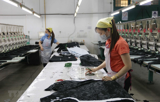 Công nhân Công ty TNHH Thêu Vĩnh Dương (quận Tân Phú) duy trì sản xuất trong những ngày dịch COVID-19. (Ảnh: Thanh Vũ/TTXVN) Nghị định 114/2020/NĐ-CP: Động lực tiếp sức doanh nghiệp vượt khó ảnh 1