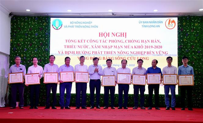 Trao tặng bằng khen cho tập thể, cá nhân hoàn thành tốt nhiệm vụ trong phòng, chống hạn, mặn mùa khô 2019-2020 vùng Đồng bằng sông Cửu Long. (Ảnh: Thanh Bình/TTXVN) Tìm ra phương thức sản xuất phù hợp để hạn chế tác động của hạn mặn ảnh 1