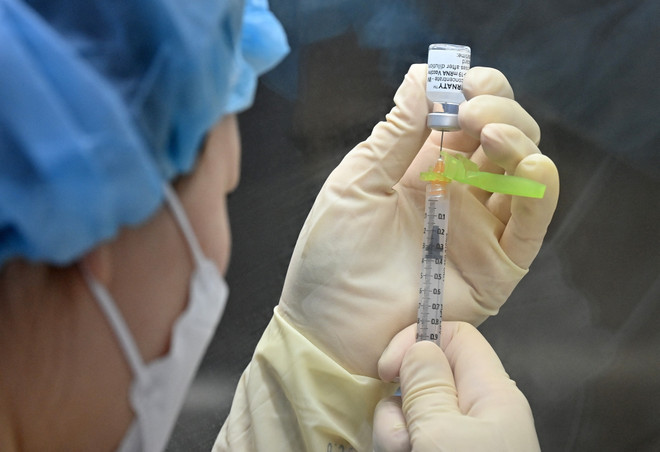 Nhân viên y tế chuẩn bị mũi tiêm vaccine phòng COVID-19. (Ảnh: AFP/TTXVN) Kỳ vọng về vaccine mới vừa chống cúm mùa vừa phòng COVID-19 ảnh 1
