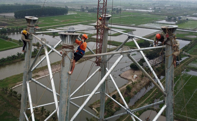 Thi công lắp cột tại vị trí 92 (huyện Nga Sơn, Thanh Hóa). (Ảnh: Huy Hùng - TTXVN) ttxvn_duong_day_500kv_mach_3_tu_thanh_hoa_den_hung_yen_2505-2.jpg