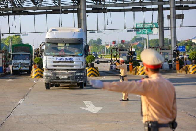 Một chốt kiểm soát dịch COVID-19 với các phương tiện và người lái trước khi vào thành phố. (Ảnh: Minh Sơn/Vietnam+) Bộ GTVT lập 4 Tổ kiểm tra về luồng xanh vận tải các tỉnh phía Nam ảnh 1