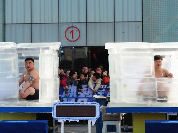 Hai thí sinh ngồi trong đá lạnh. (Nguồn: AFP/ TTXVN) Chịu đựng 48 giờ không ăn, ngồi trong đá lạnh để lập kỷ lục ảnh 1