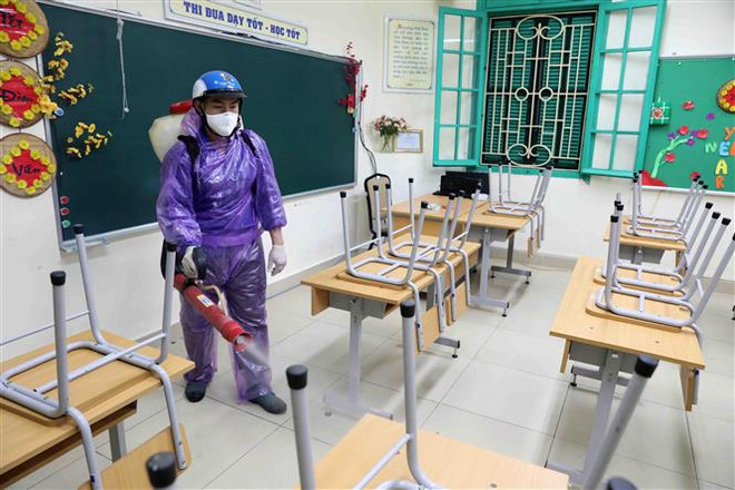 Trường THCS Trưng Vương, quận Hoàn Kiếm, Hà Nội, tiến hành phun thuốc khử khuẩn trong sáng ngày 14/2. (Ảnh: Thanh Tùng/TTXVN) Bộ Giáo dục và Đào tạo sẽ lùi thời điểm kết thúc năm học ảnh 1