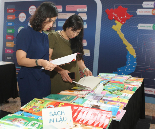 Đại biểu dự hội thảo xem những ấn phẩm in lậu. (Ảnh: Thanh Tùng/TTXVN) Nâng cao nhận thức về chống vi phạm bản quyền với xuất bản phẩm ảnh 1