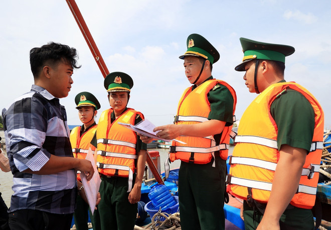 Cán bộ, chiến sỹ đồn Biên phòng Rạch Gốc (Cà Mau) kiểm tra giấy tờ theo quy định đối với chủ tàu cá. (Ảnh: Hồng Đạt/TTXVN) Người lính “quân hàm xanh” vững vàng nơi tiền đồn Tây Nam Tổ quốc ảnh 2