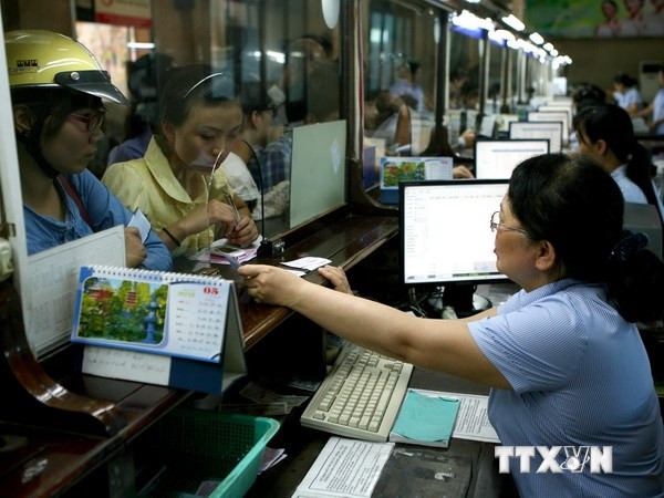 Khách mua vé tàu tại ga Hà Nội. Ảnh: Huy Hùng/TTXVN) Đường sắt Việt Nam giảm giá đối với hành khách đi tàu tập thể ảnh 1