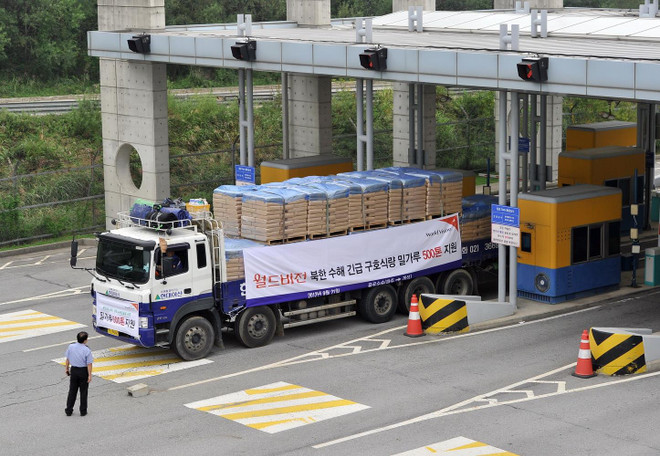 Xe tải của Hàn Quốc chở bột mì viện trợ cho Triều Tiên qua cửa khẩu biên giới tỉnh Paju. (Ảnh: AFP/TTXVN) Hội Chữ thập đỏ kéo dài thời gian viện trợ khẩn cấp cho Triều Tiên ảnh 1
