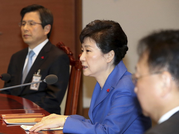 Tổng thống Park Geun-hye (giữa) và Thủ tướng Hwang Kyo-ahn (trái) tại phiên họp nội các khẩn ở Seoul ngày 9/12. (Nguồn: AP/TTXVN) Chính quyền Hàn Quốc cố ổn định tình hình do vụ luận tội Tổng thống ảnh 1