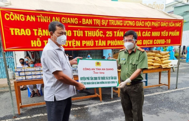 Đại tá Đinh Văn Nơi, Giám đốc Công an tỉnh trao bảng hỗ trợ quà cho lãnh đạo huyện Phú Tân, An Giang. (Ảnh: Thanh Sang/TTXVN) An Giang: Tặng thuốc, gạo hỗ trợ huyện Phú Tân chống COVID-19 ảnh 1