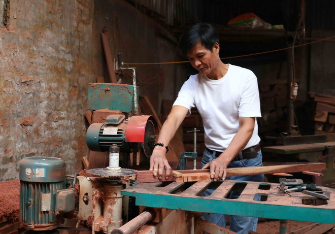 Anh Nguyễn Ngọc Du pha hàng gỗ tại xưởng sản xuất của gia đình. (Ảnh: Thanh Thương/TTXVN) Vượt qua mặc cảm tù tội để làm kinh tế giỏi, giúp đỡ người nghèo ảnh 1