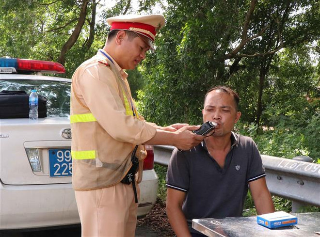 Lực lượng Cảnh sát giao thông tỉnh Bắc Ninh tiến hành kiểm tra nồng độ cồn trong người của người tham gia giao thông. (Ảnh: Thanh Thương/TTXVN) Tăng cường xử lý vi phạm về ma túy, nồng độ cồn từ nay đến cuối năm ảnh 1