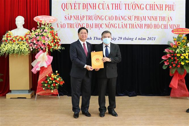 Chủ tịch UBND tỉnh Ninh Thuận Trần Quốc Nam (trái) trao Quyết định của Thủ tướng Chính phủ sáp nhập Trường Cao đẳng sư phạm Ninh Thuận vào Trường Đại học Nông Lâm Thành phố Hồ Chí Minh. (Ảnh: Công Thử/TTXVN) Bàn giao Trường CĐ Sư phạm Ninh Thuận vào Đại học Nông lâm TP.HCM ảnh 1