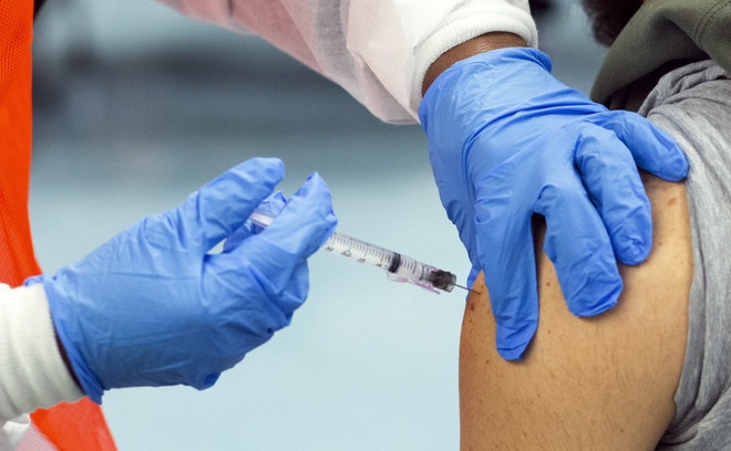Nhân viên y tế tiêm vaccine phòng COVID-19 cho người dân tại New York, Mỹ. (Ảnh: AFP/TTXVN) Mỹ có thể bắt buộc nhân viên liên bang tiêm phòng vaccine ảnh 1