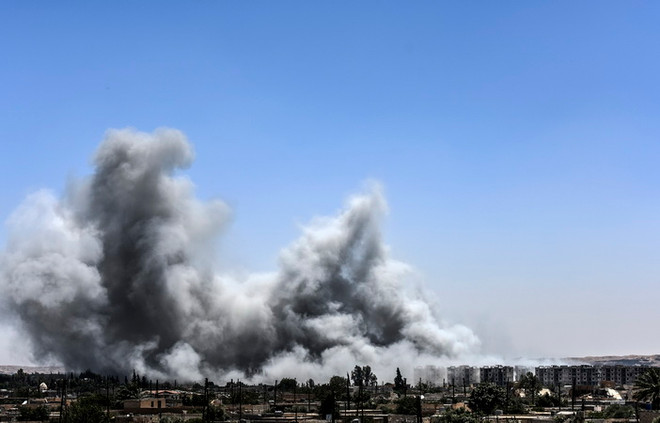 Khói bốc lên sau một cuộc không kích ở Raqa, Syria ngày 15/7/2017. (Nguồn: AFP/TTXVN.) Nga cảnh báo Mỹ không kích Syria sẽ là tội ác chiến tranh ảnh 1
