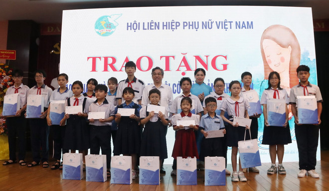 Các đại biểu tặng quà cho trẻ mồ côi tại Thành phố Hồ Chí Minh. (Ảnh: Thu Hương/TTXVN) ttxvn_lien hiep phu nu (2).jpg