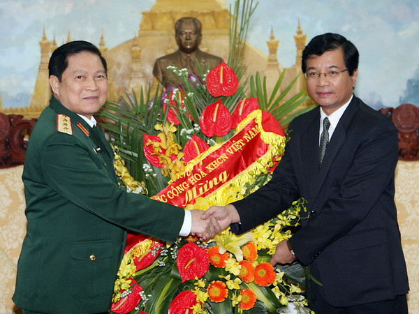 Thượng tướng Ngô Xuân Lịch chúc mừng Đại sứ Cộng hòa Dân chủ nhân dân Lào Somphon Sichalon. (Ảnh: Trọng Đức/TTXVN) Chúc mừng 65 năm ngày thành lập Quân đội nhân dân Lào ảnh 1